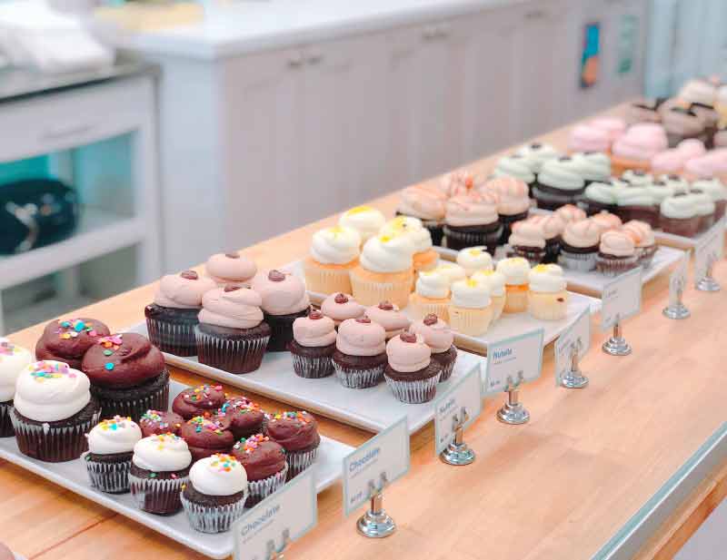 delicious colorful cupcakes displayed on store bench
